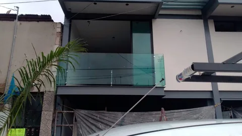 Balcón con barandal de cristal y cubierta de aluminio en fachada moderna