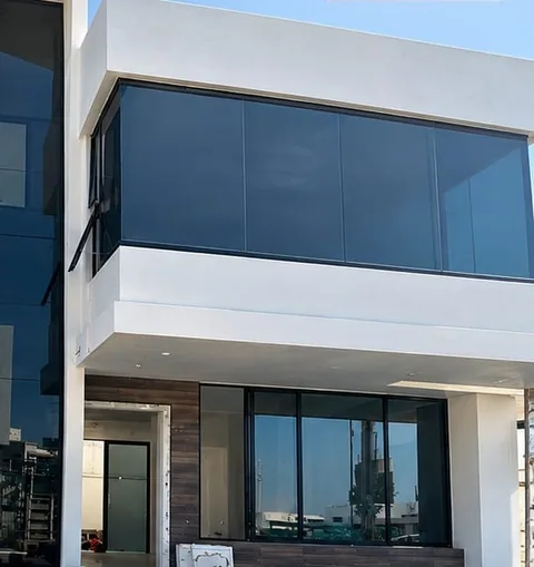 Vivienda moderna con fachada de cristal y ventanales de piso a techo