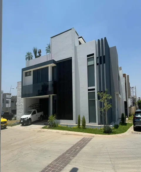 Casa moderna con barandal de cristal en el balcón y celosía de aluminio negro